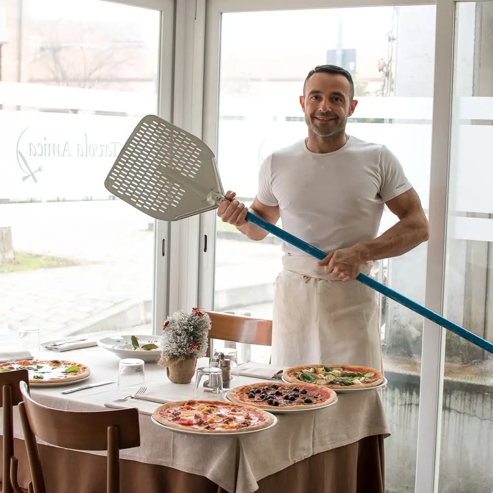 Il pizzaiolo con la pala davanti al forno